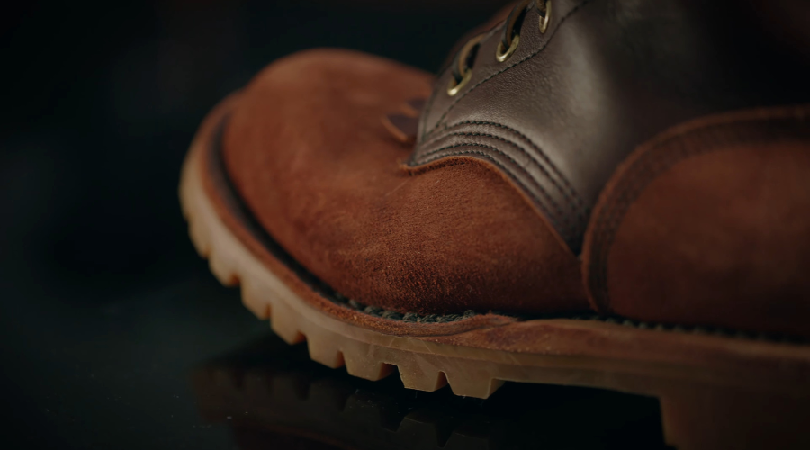 Detaljan prikaz prednjeg dela radne cipele od brušene i glatke kože, sa izraženim đonom i šavovima.